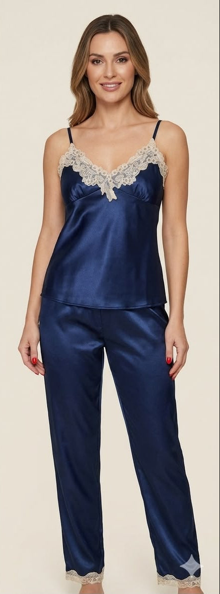 Woman wearing a navy satin pajama set with lace trim on a beige background